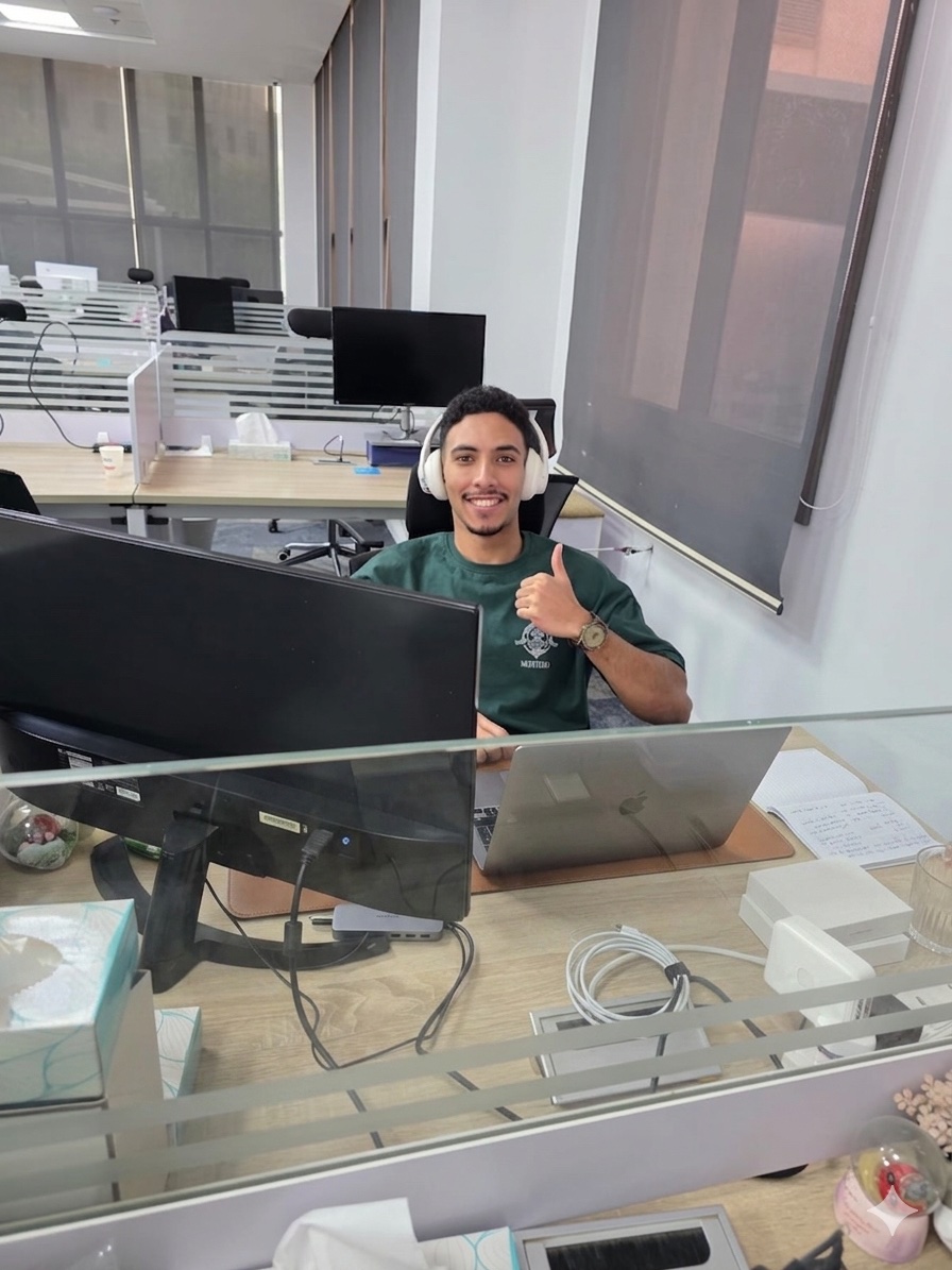 Ahmed at his desk at Incorta, headphones on, thumbs up