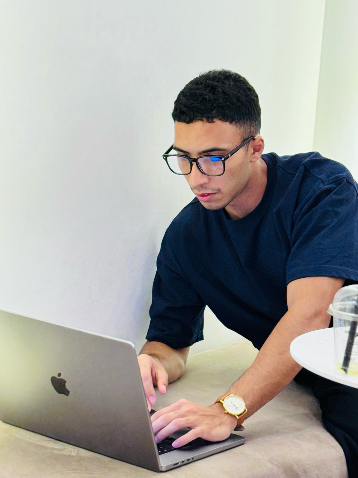 Ahmed in glasses, typing on a laptop